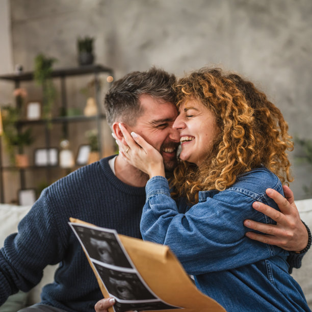 一对情侣打开信封，里面是他们宝宝的超声波孕期照片图片下载