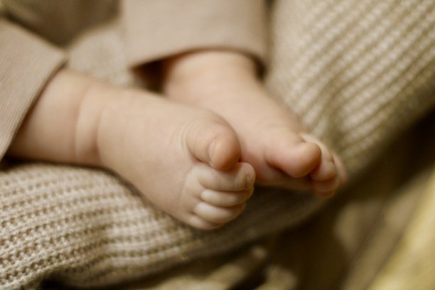 婴儿的脚踩在柔软的毛毯上，特写照片图片下载