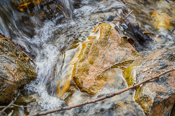 清澈山河的特写照片，水流在大石头周围模糊运动中冻结，阳光明媚的白天。图片下载