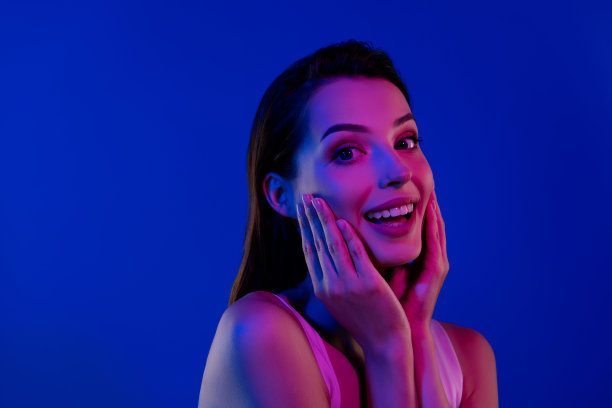迷人女士在蓝色背景下，经过创新美容程序后，肌肤清新纯净的照片图片下载