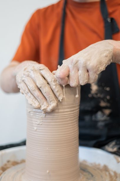 陶艺师的双手在陶轮上制作陶瓷花瓶的特写。竖版照片。图片下载