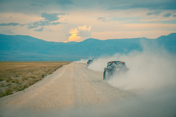 在阿尔泰沙漠的越野旅行。山地风景，丘陵与美丽的蓝天和背景中的云朵。越野车在尘土飞扬的泥土路上行驶。阿尔泰共和国的积极休闲活动。图片下载