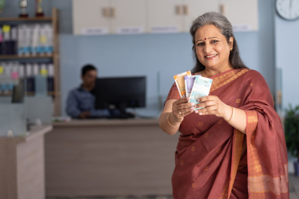 穿着纱丽的老年女性在银行展示印度货币的库存照片图片下载
