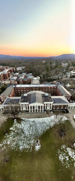 这张垂直全景无人机照片捕捉了弗吉尼亚大学的壮观鸟瞰图，视角从圆形大厅朝向步行桥。图片下载