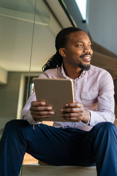 成功的非裔美国商人在数字平板上阅读商业图表和股票走势图图片下载