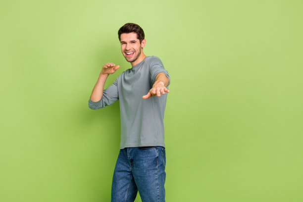 一位兴奋的帅气男友在绿色背景下邀请他的女友与他共舞的照片图片下载