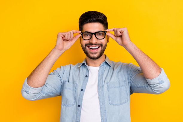 年轻男孩佩戴亚马逊新款时尚眼镜的特写照片，背景为黄色。图片下载