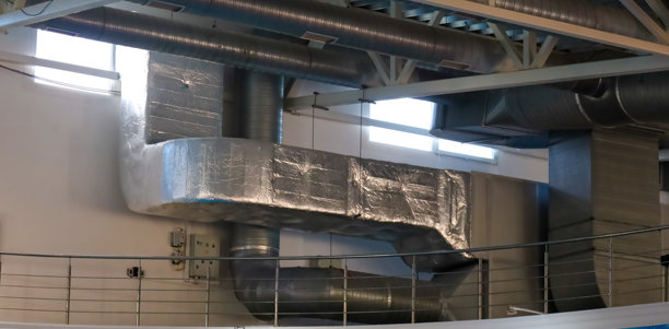 全景照片展示了一个复杂的通风管道系统，贯穿了一个宽敞的房间，房间的全景窗几乎占据了整面墙。图片下载