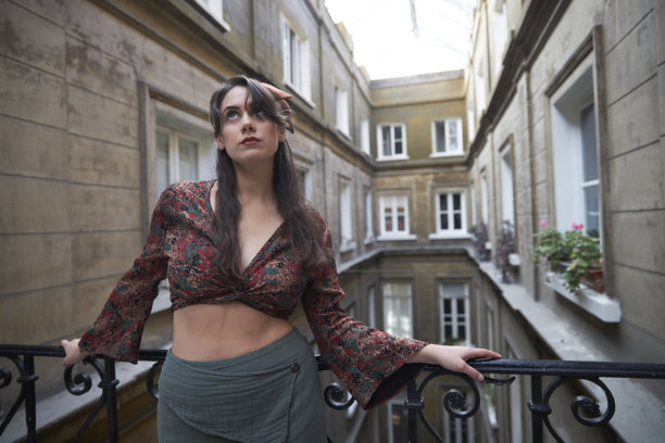 年轻的白人女性在一座老建筑的阳台上摆姿势的照片系列图片下载