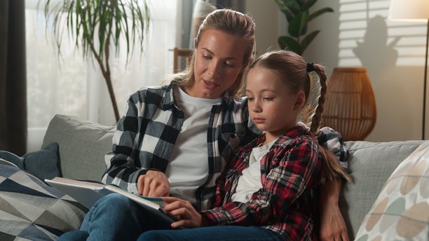 白人家庭在家中客厅放松，快乐地交谈，母亲与可爱的收养女孩一起看照片册，进行对话，阅读书籍，享受摄影时光。图片下载