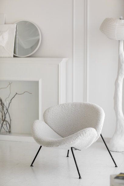 现代室内设计，白色 boucle 面料扶手椅配黑色金属腿，背景为浅色空墙，展现了客厅的工业风和复古风格。室内家具。极简主义概念。图片下载