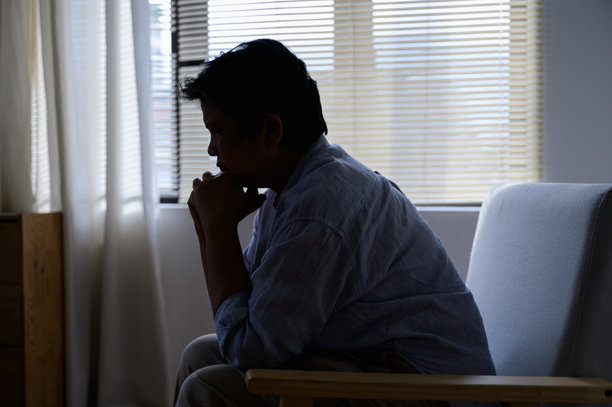 老年亚洲女性的剪影照片，感到沮丧、悲伤、不快乐或失望，孤独地在房间里哭泣。老年人心理健康护理问题的生活方式概念。图片下载