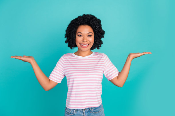 可爱的年轻女士在水绿色背景下穿着时尚的条纹服装，手持空白空间的照片肖像。图片下载