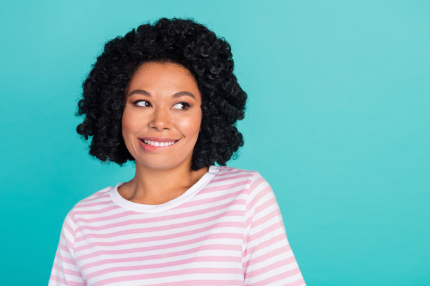 可爱的年轻女士的照片肖像，咬着嘴唇，目光空洞，穿着时尚的条纹服装，背景为水绿色。图片下载