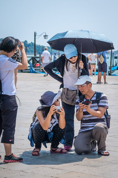游客在威尼斯的炎热天气中比较照片图片下载