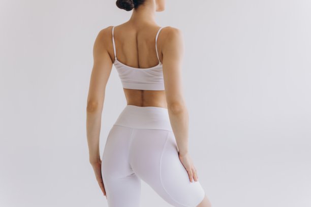女性运动服。品牌服装。积极的生活方式。健身服装。女性运动员背影，完美的臀部和苗条的身材，黑色标志样本。图片下载