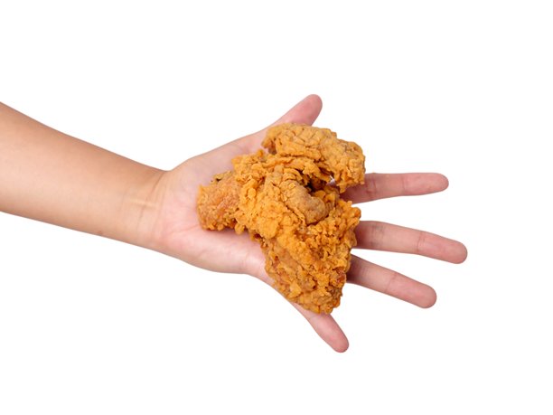 手握酥脆炸鸡块的照片，背景简单，非常适合食品摄影图片下载