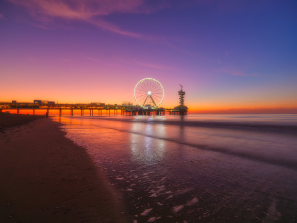 海牙，荷兰。海滨码头和摩天轮。荷兰著名的海滩景点。日落时的海岸。放松的沙滩。适合用作背景、壁纸和明信片的照片。图片下载