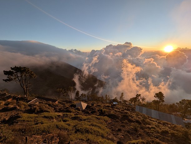 从危地马拉安提瓜附近的阿卡滕戈火山顶上拍摄的无人机航拍照片，阳光透过云层洒落在云朵上。图片下载