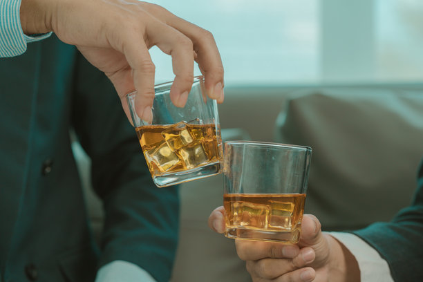 商人们在一个黑暗的房间里讨论工作，喝着Vikis，特写照片图片下载