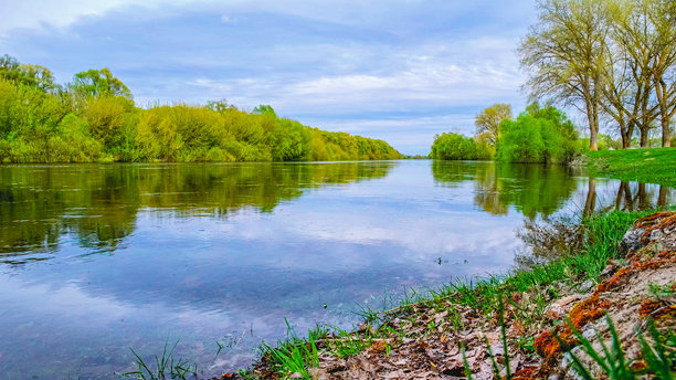 美丽的春季绿色风景，流淌的河流和蓬松的云朵。春天的美丽自然。没有人。夏季风景的照片，天空多云。图片下载
