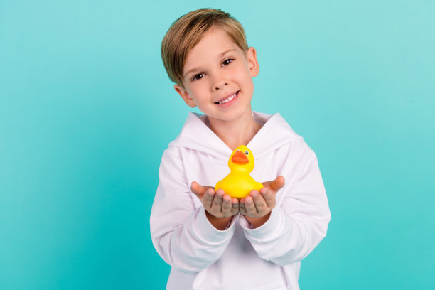 可爱的孩子在青色背景下与浴室里的动物鸭子分享礼物的照片图片下载