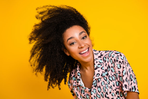 漂亮年轻女孩在黄色背景下兴奋地摆动头发，穿着时尚的豹纹服装的照片肖像图片下载