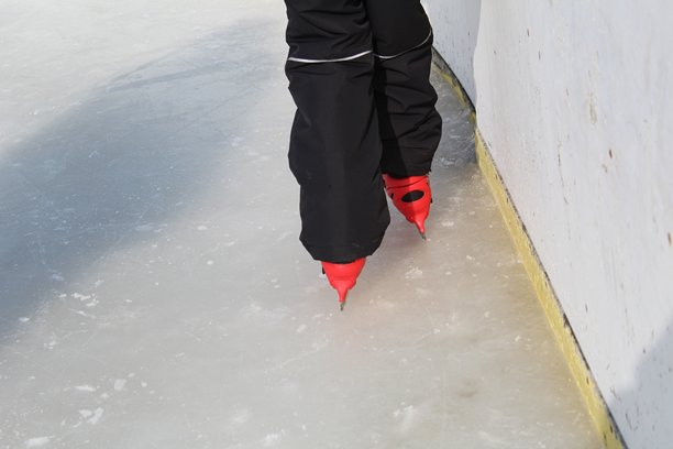 一个男孩在冰场滑冰的腿部特写照片图片下载