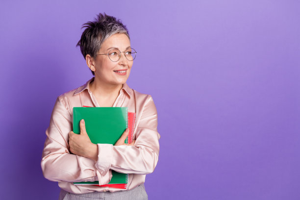 吸引人的退休女性的照片肖像，穿着时尚的缎面衣服，目光空洞地看着空间，背景为紫色。图片下载