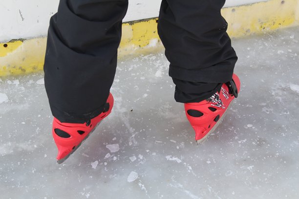 一个男孩在冰场滑冰的腿部特写照片图片下载