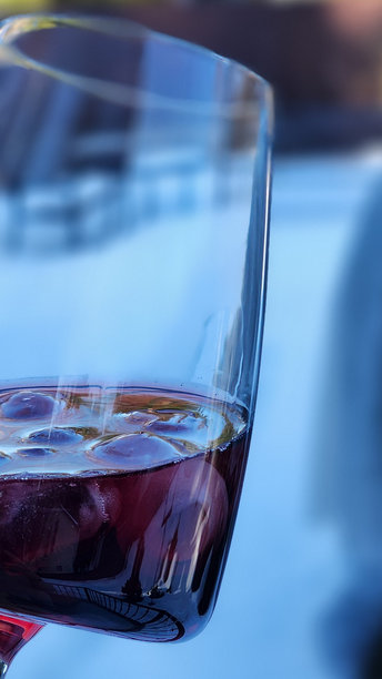 女性手持红酒杯，背景为自然风光。竖版照片图片下载