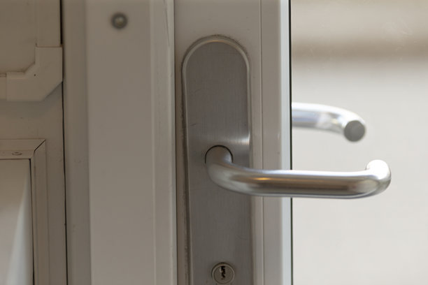 这张图片展示了白色门上的门把手特写。图片下载