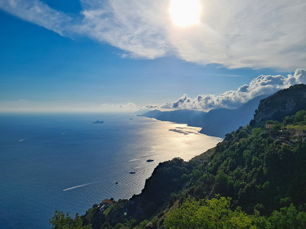 意大利阿马尔菲海岸著名的“众神小径”上，阳光明媚的夏日，海洋的景色，云彩与阳光在波浪上反射，意大利，自然库存照片图片下载