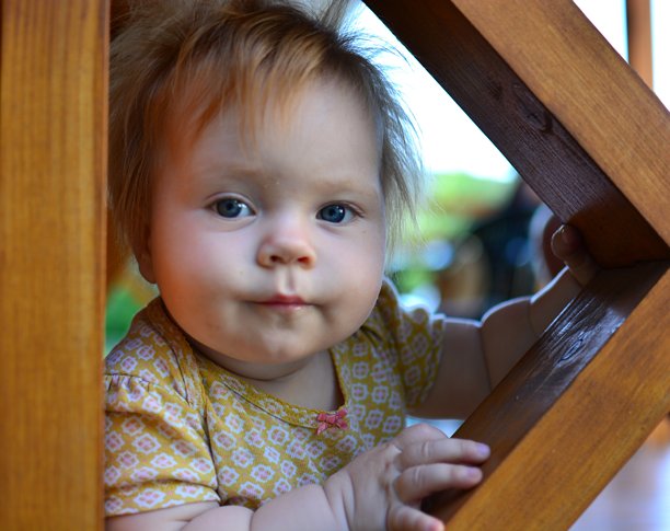 穿着黄色连体衣的红发小女孩特写头像。幼儿女孩在夏天户外玩得很开心。图片下载