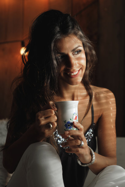 阳光透过百叶窗照亮了一位美丽年轻女性的照片。图片下载