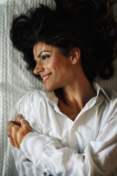 阳光透过百叶窗照射在一位美丽年轻女性的躺姿照片。图片下载