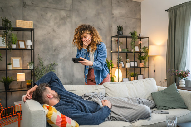 女朋友在沙发上拍她睡着的男朋友的照片图片下载