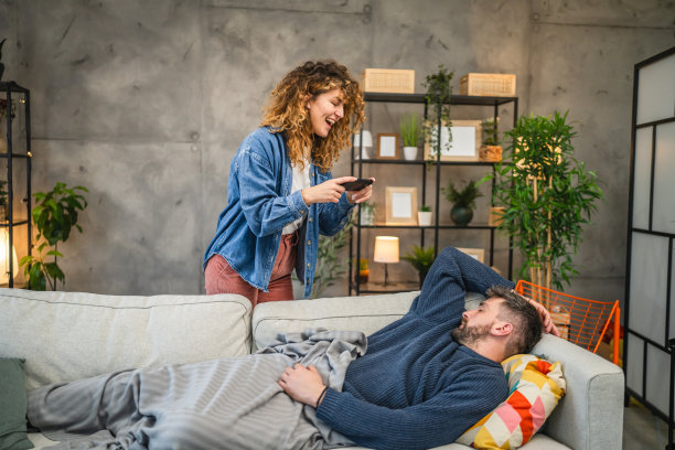 女朋友在沙发上拍她睡着的男朋友的照片图片下载