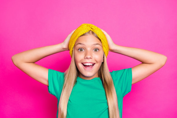 惊讶的孩子近距离照片，听到好消息大喊“哇，天哪！”穿着蓝色T恤，背景为粉色。图片下载