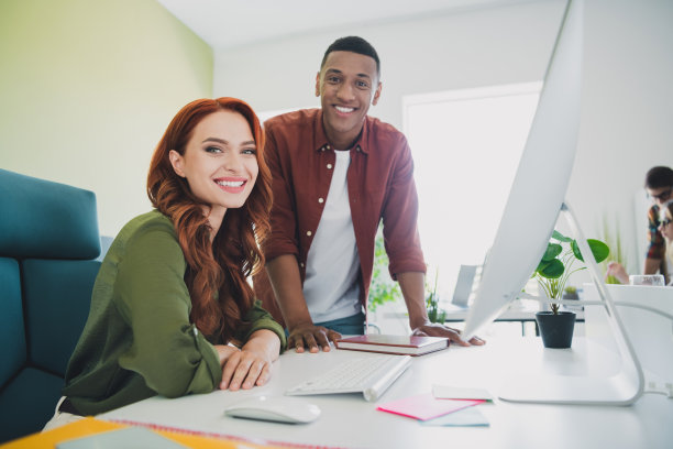 年轻企业员工在办公室商务中心的工作站前使用电脑的照片图片下载