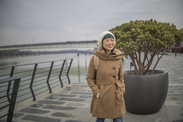 日本女性在欧洲城市的照片中探索，并在河岸上休息。图片下载