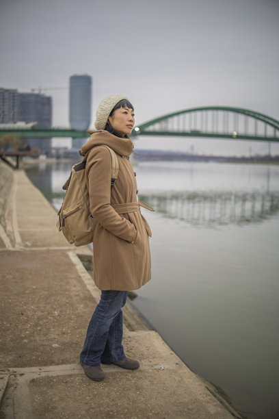 日本女性在欧洲城市的照片中探索，并在河岸上休息。图片下载