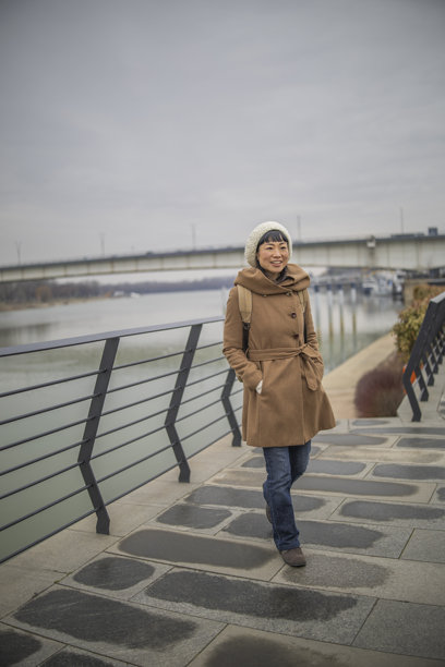 日本女性在欧洲城市的照片中探索，并在河岸上休息。图片下载