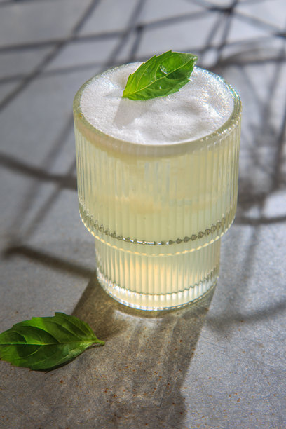 这张图片展示了一杯精美调制的鸡尾酒或无酒精鸡尾酒，盛在高高的有纹理的玻璃杯中。图片下载