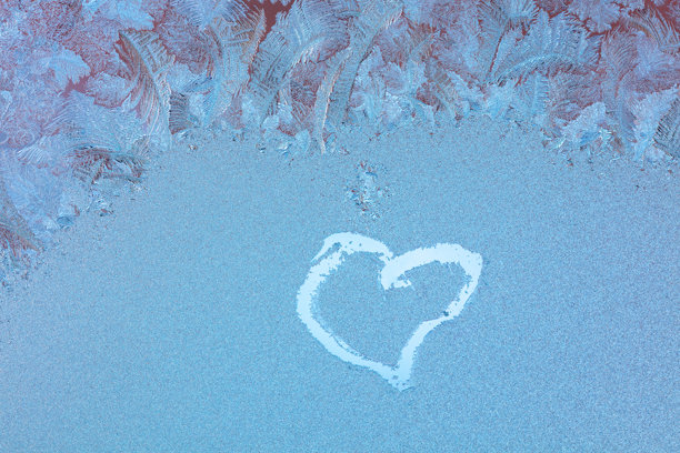 冰冻窗户上的心形图案。粉色光线中的抽象照片背景。情人节和爱情概念。图片下载