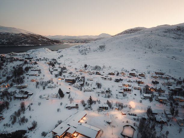 挪威特罗姆瑟的埃尔斯峡湾村庄，坐落在峡湾之间的雪山上，航拍照片。图片下载
