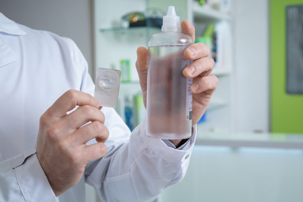 男性手握着镜头和装有液体的瓶子的特写照片图片下载