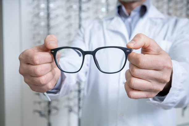 手持眼镜的男性眼科医生特写照片图片下载