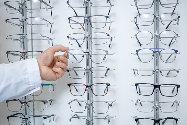 男性眼科医生手持眼镜的特写照片图片下载