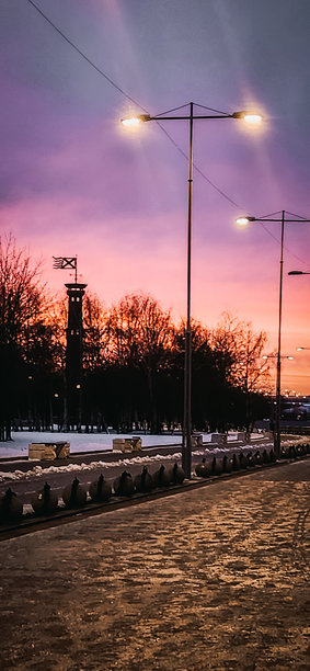 壮丽的冬季风景在火红的黎明中。圣彼得堡300周年公园的灯塔剪影和步行小径。竖版照片图片下载